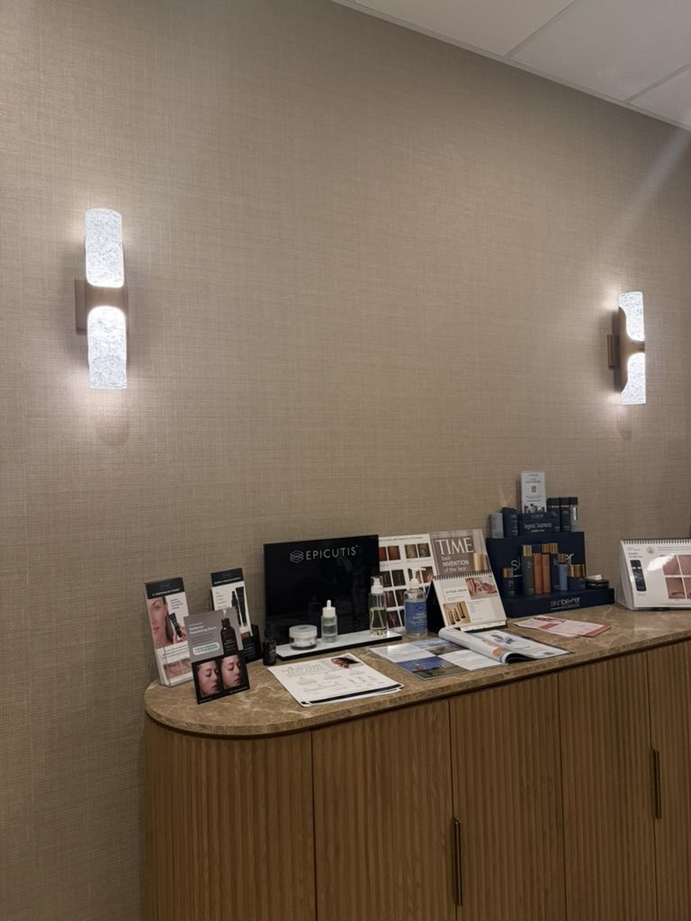 The skincare retail wall at The Glow Suite, Suite 601, with wall sconces and product displays